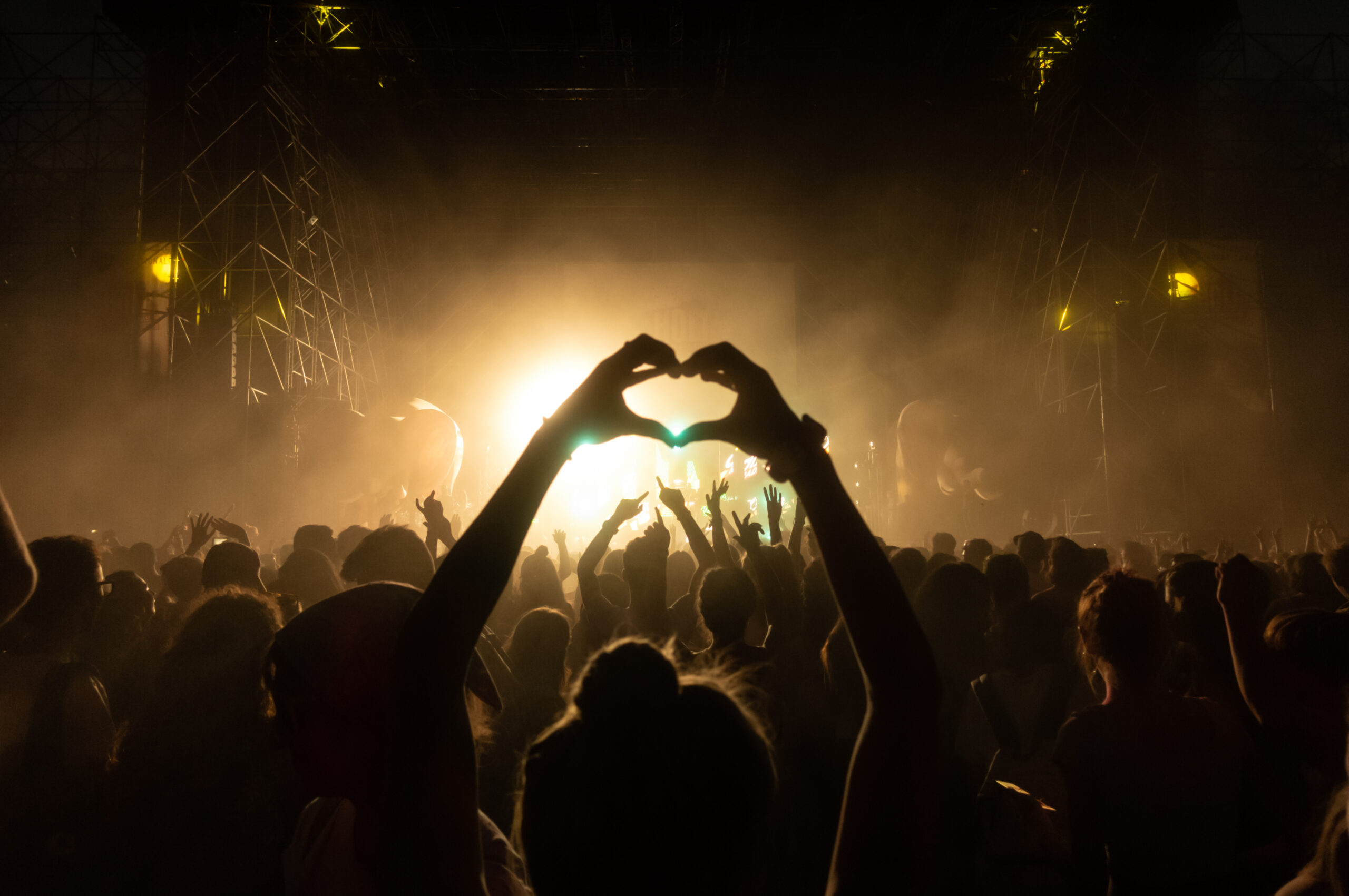 Crowd having party at the concert - Moltitude of people having fun at an event, strobe lights and confetti in the background